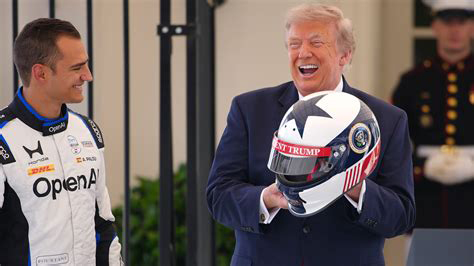 President Trump holds helmet presented to him ahead of the Freedom 250 Grand Prix
